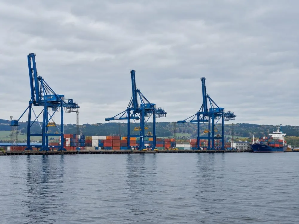 Containerkrane und gestapelte Frachtboxen auf Sjursøya am östlichen Ufer des Fjords – der Arbeitshafen, der im selben Gewässer wie die Ausflugsboote liegt.